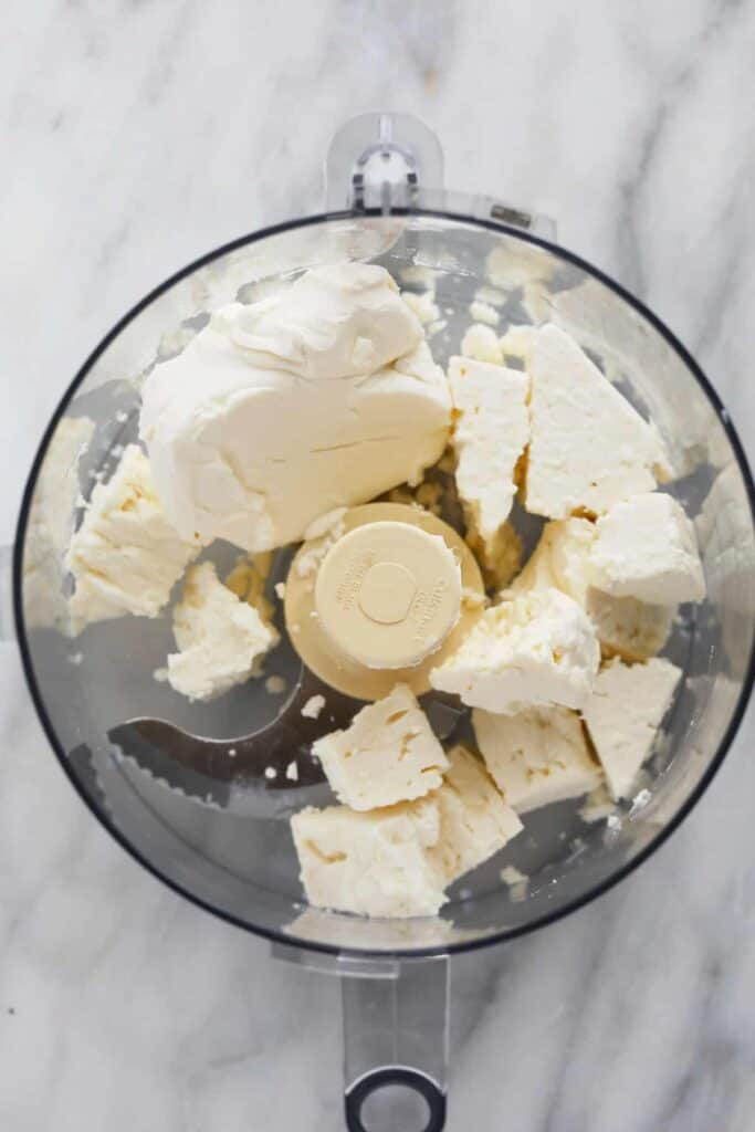 Whipped feta dip ingredients in a food processor ready to be blended to creamy perfection.