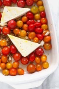 a baking dish filled with tomatoes and cheese.