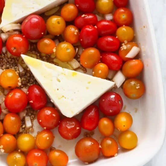 a baking dish filled with tomatoes and cheese.