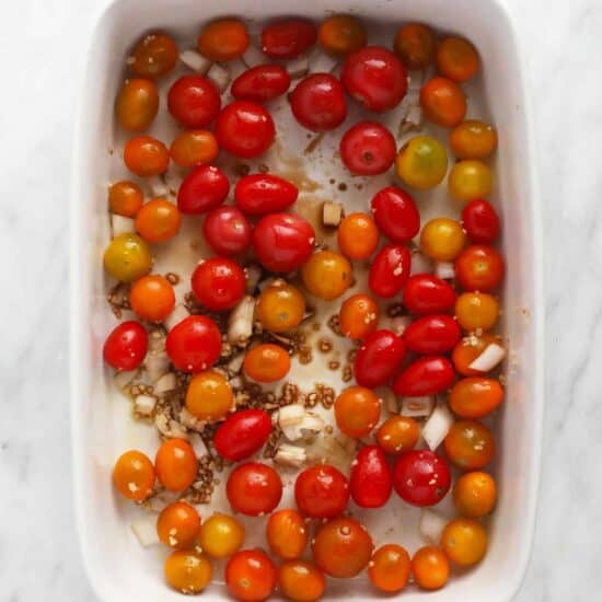 roasted cherry tomatoes in a white baking dish.