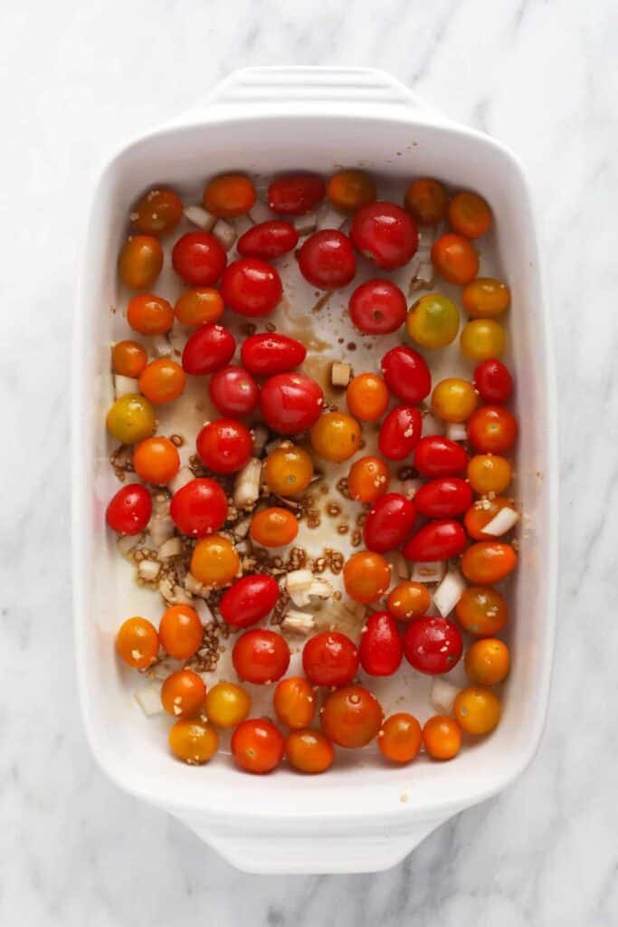 cherry tomatoes, onion, garlic, and balsamic vinegar in casserole dish