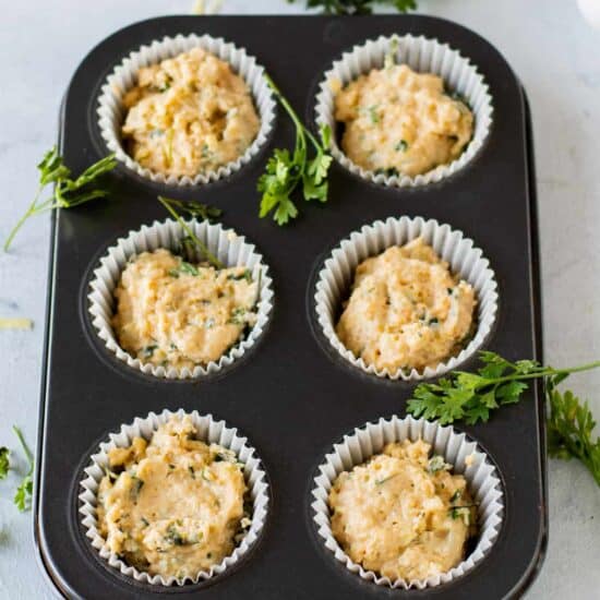 Cheese muffins baked in a muffin tin with parsley.