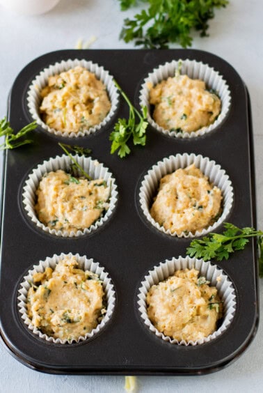 Cheese muffins baked in a muffin tin with parsley.