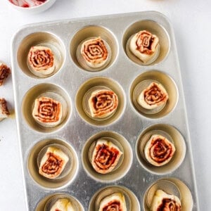 a muffin tin with chocolate raspberry muffins