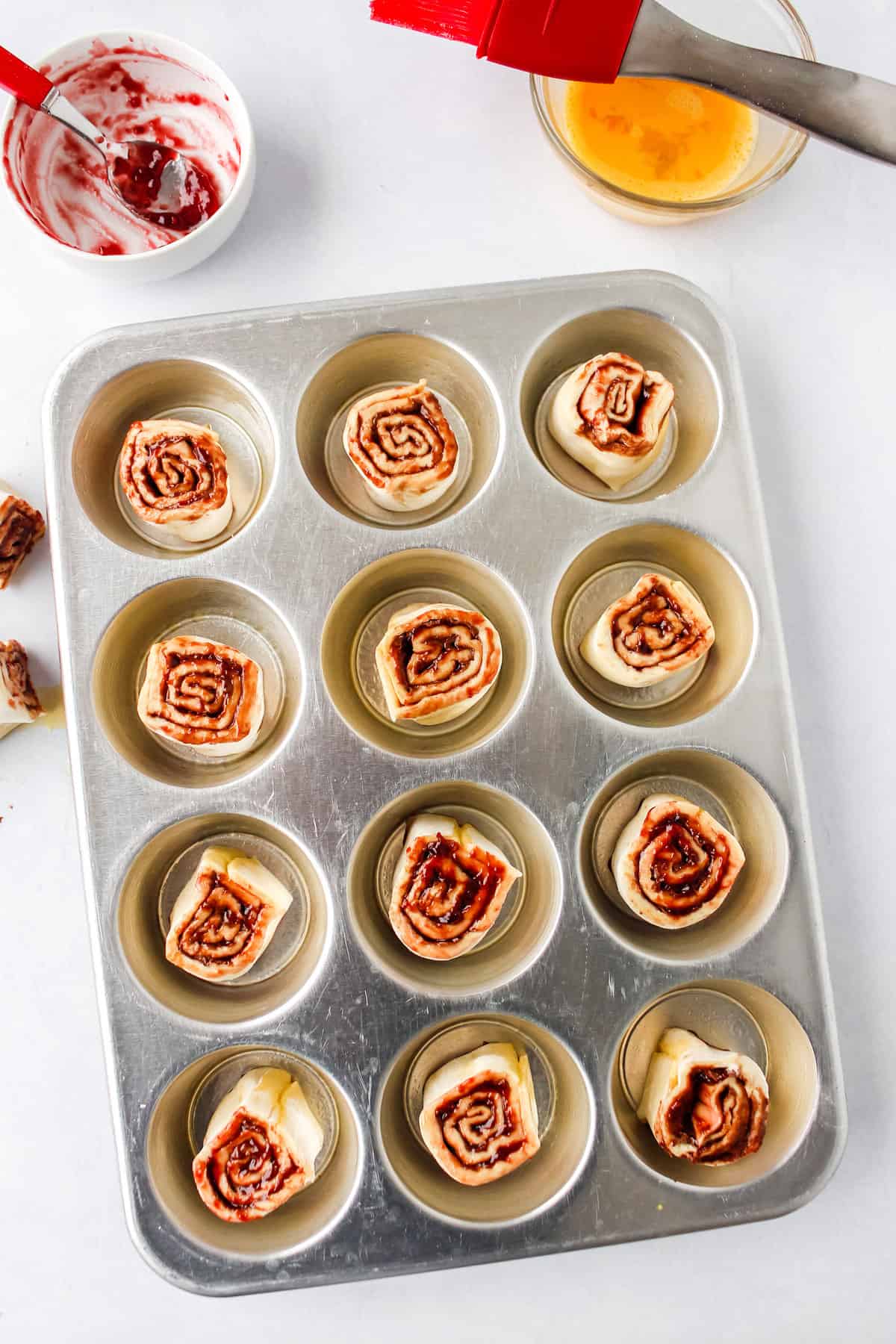 raw chocolate cinnamon rolls in a muffin tin, ready to be baked