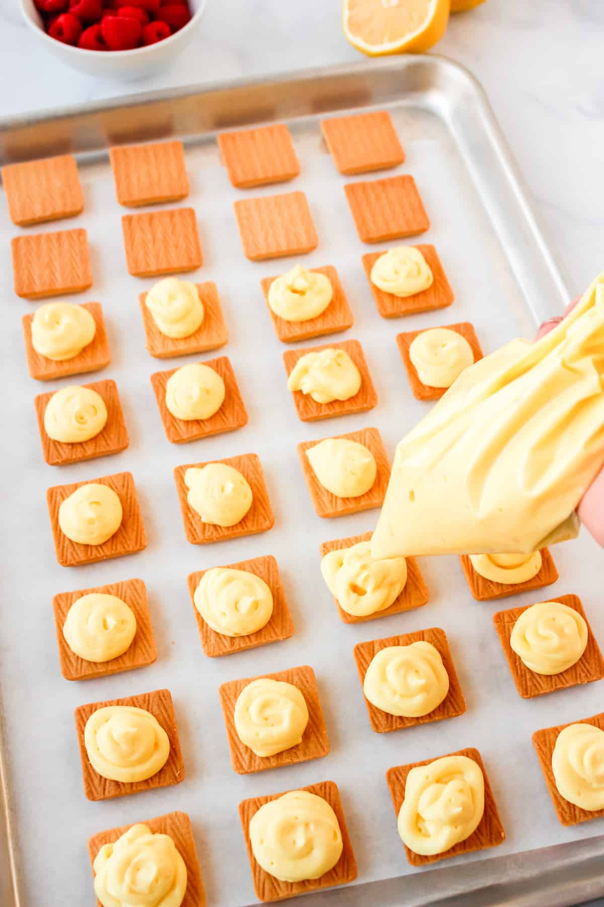 piping lemon filling onto shortbread cookies