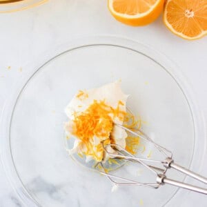 a glass bowl with orange slices and a fork.