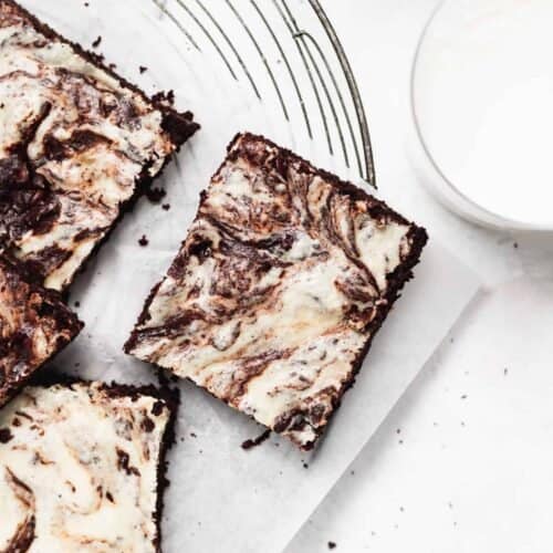 Cream cheese brownies on a cutting board.