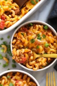 two bowls of macaroni and cheese casserole with a fork.