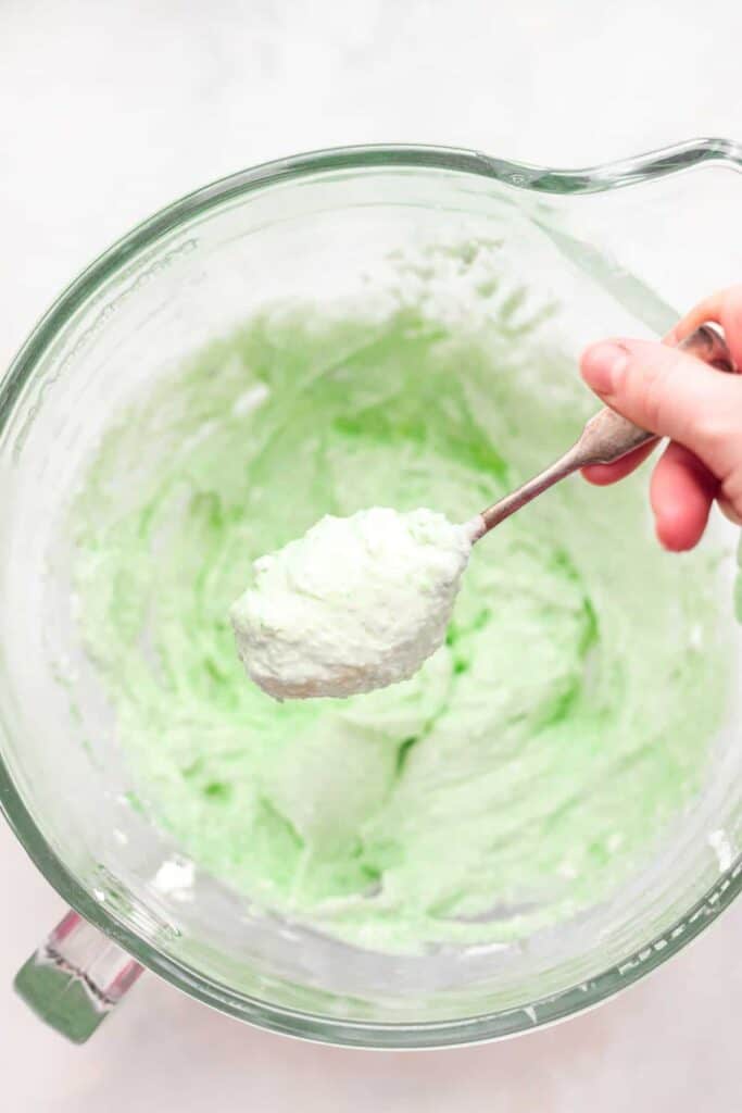 Pistachio pie filling on a spoon, ready to be dolloped into pistachio pie cups.