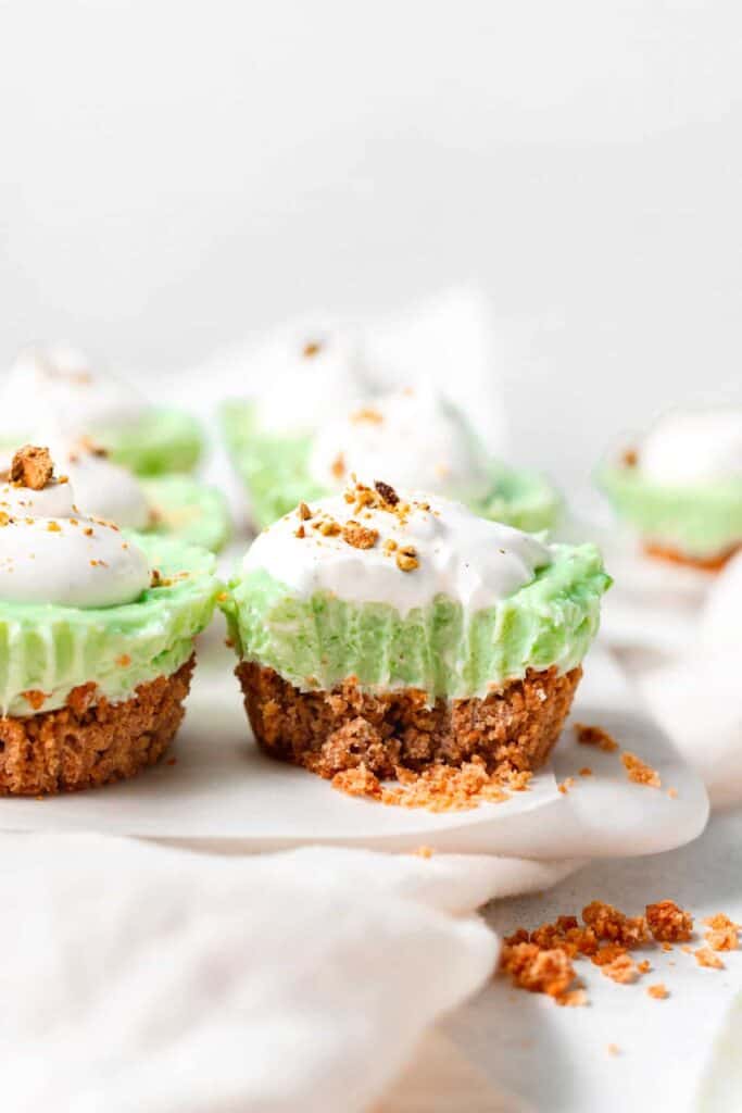 Pistachio pie cups with a bite taken out of one of them.