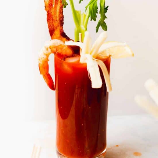a bloody mary with bacon and bloody mary skewers as garnishes.