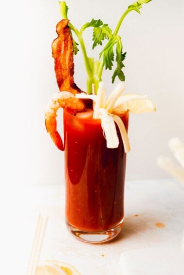 a bloody mary with bacon and bloody mary skewers as garnishes.