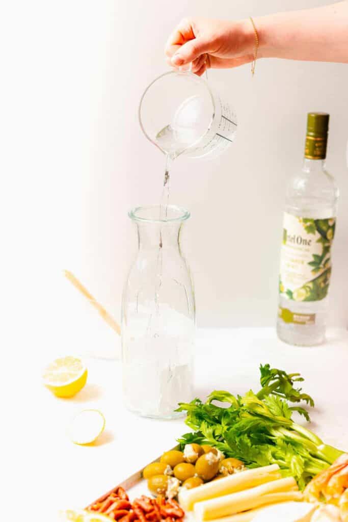 vodka being poured in a pitcher for bloody marys