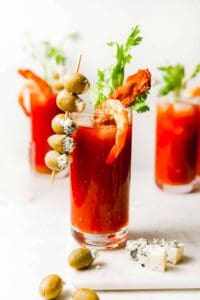 A bacon and olive bloody mary garnished with a skewer.