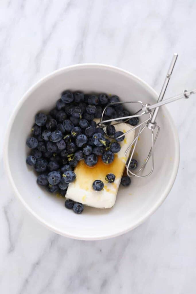 A bowl of blueberries, cream cheese, lemon juice, and lemon zest. 