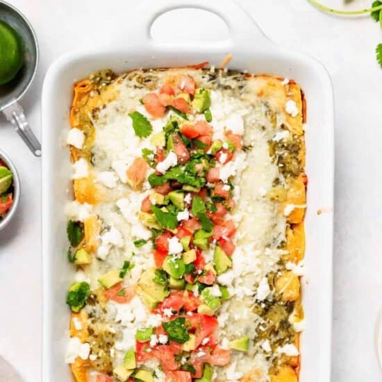 Chicken enchiladas in a casserole dish.