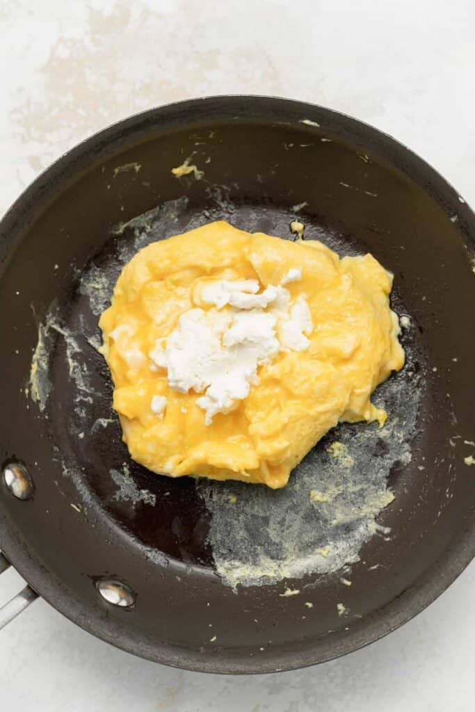 Goat cheese on top of the scrambled eggs. 