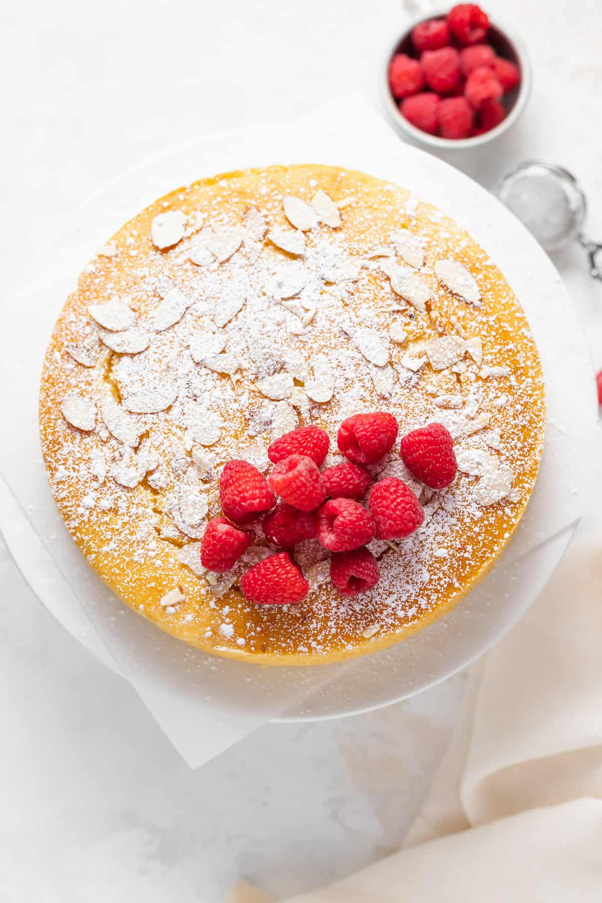 lemon ricotta cake topped with fresh berries and powdered sugar