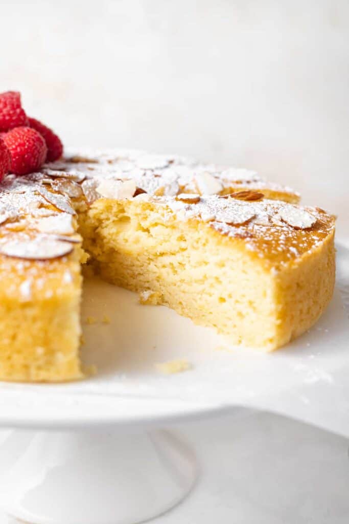 Make any occasion special with this deliciously fluffy and moist lemon ricotta cake that's made from 9 simple ingredients. Enjoy! slice of lemon ricotta cake with powdered sugar and slivered almonds