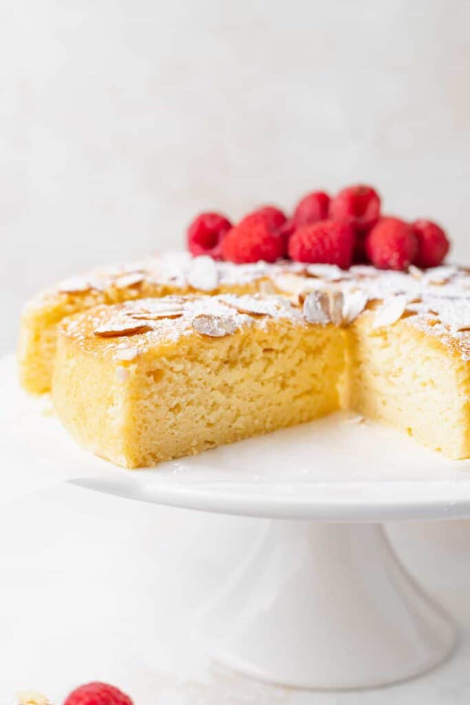 slice of lemon ricotta cake topped with powdered sugar and sliced almonds