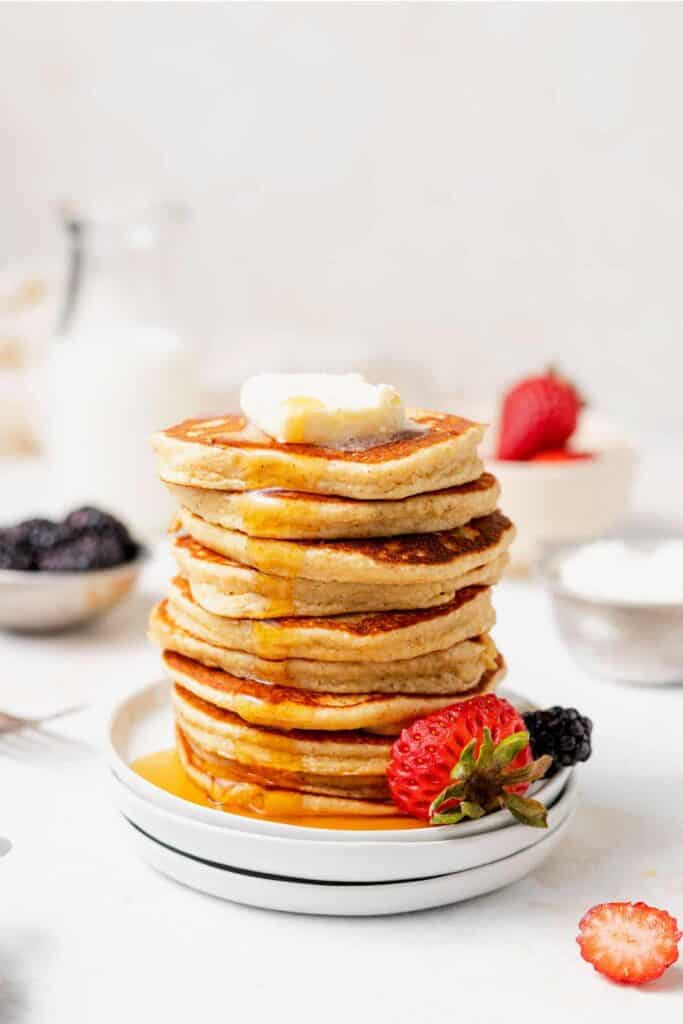 A stack of cottage cheese pancakes with a pad of butter on the top. 