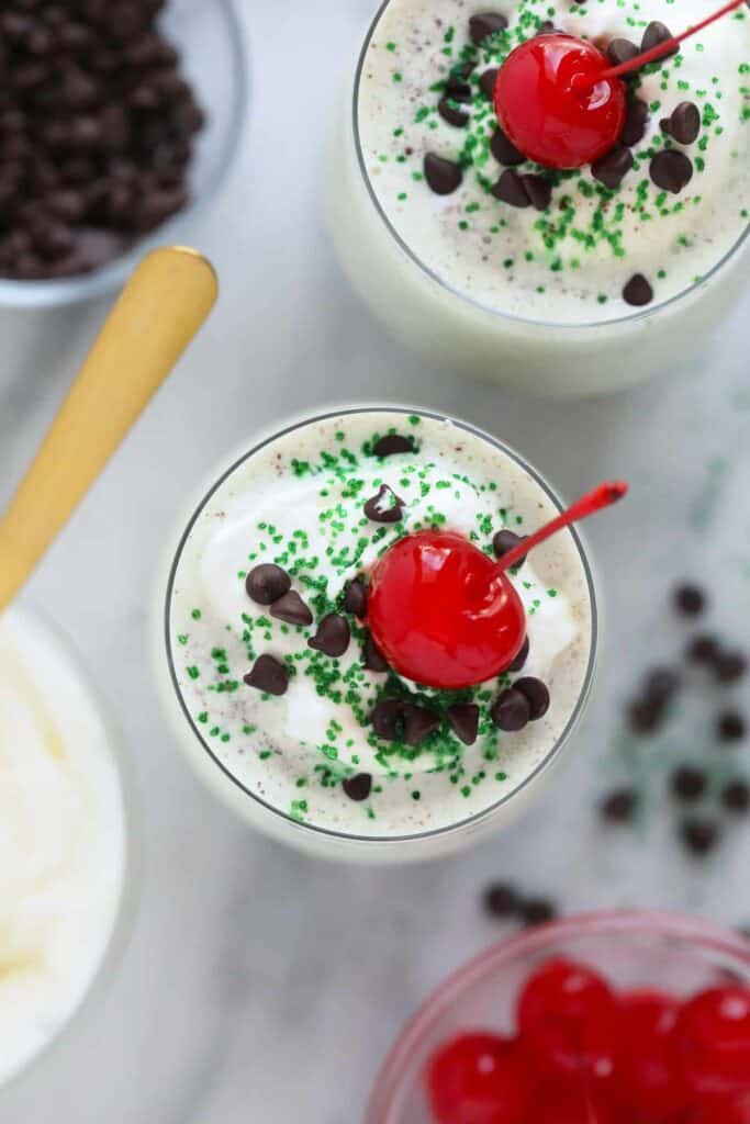 Shamrock shake with whipped cream, a cherry, and sprinkles. 