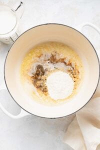 A pan with flour, eggs, and milk next to it - used for making white cheddar mac and cheese.