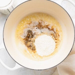 A pan with flour, eggs, and milk next to it - used for making white cheddar mac and cheese.