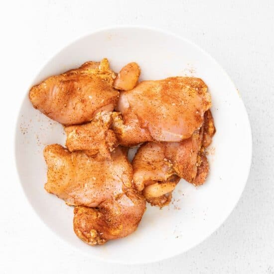 chicken wings in a white bowl on a white background.