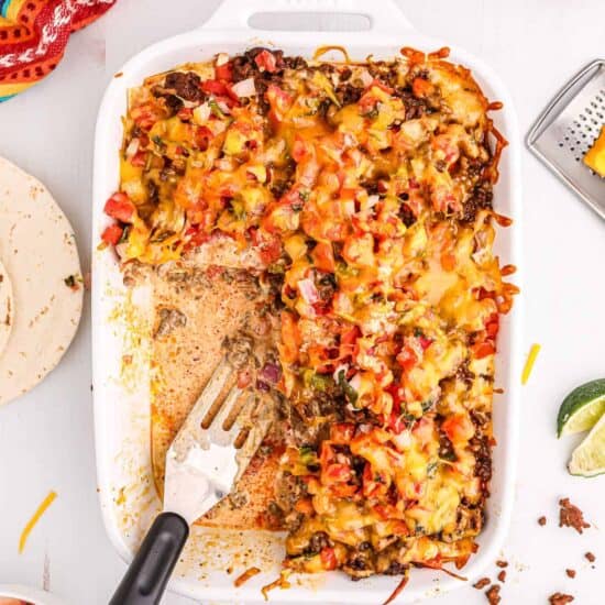 mexican casserole in a white dish with a fork.