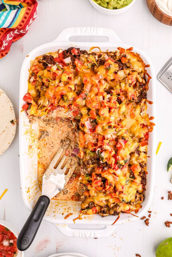 mexican casserole in a white dish with a fork.