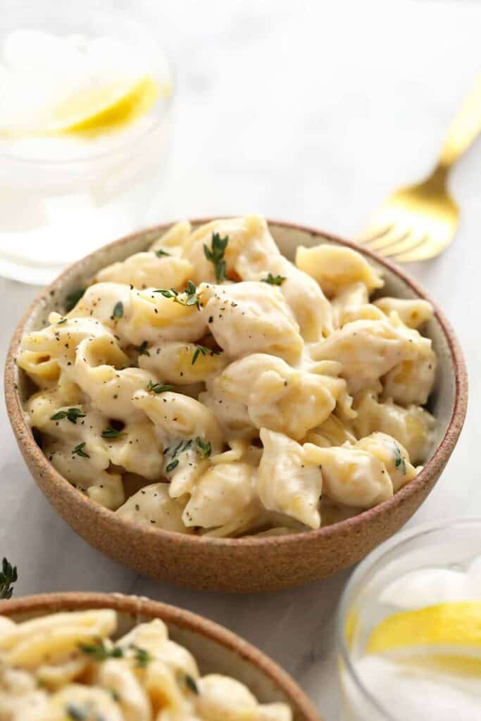 Brie mac and cheese in a bowl with chopped parsley.