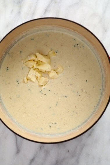 a bowl of soup with cheese and garlic in it.
