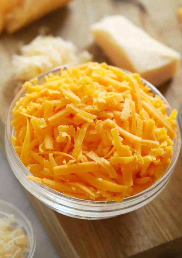 closeup of a glass bowl of shredded cheese