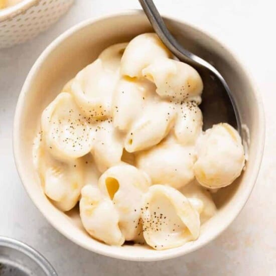 a bowl of white cheddar mac and cheese with a spoon