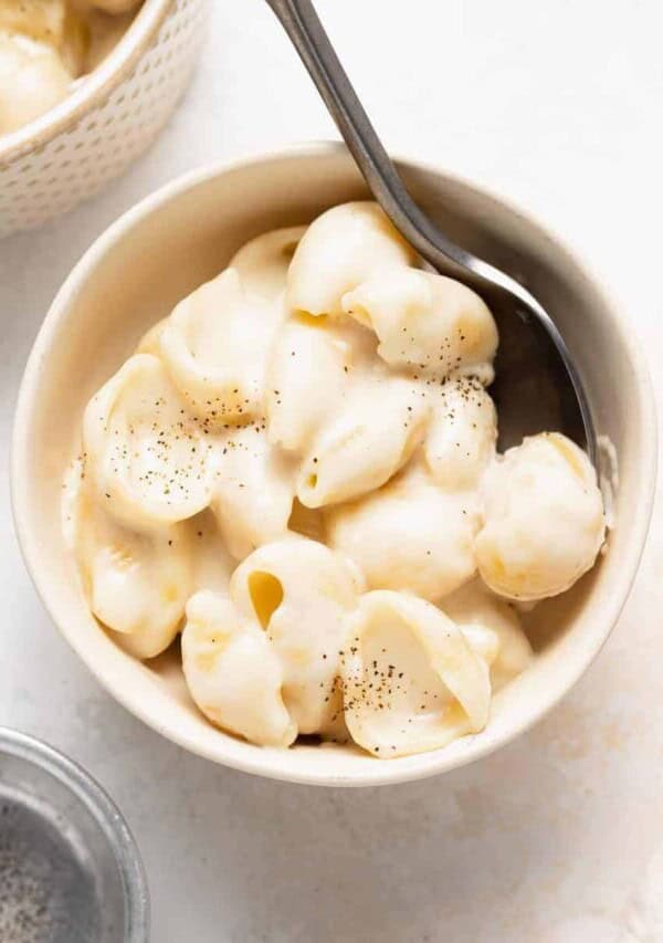 a bowl of white cheddar mac and cheese with a spoon