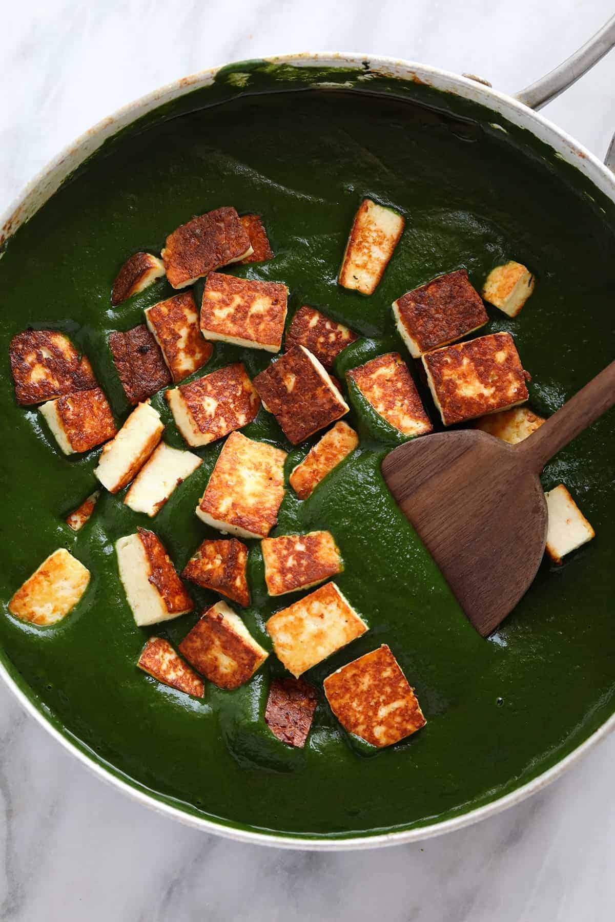 Paneer added to curry sauce. 