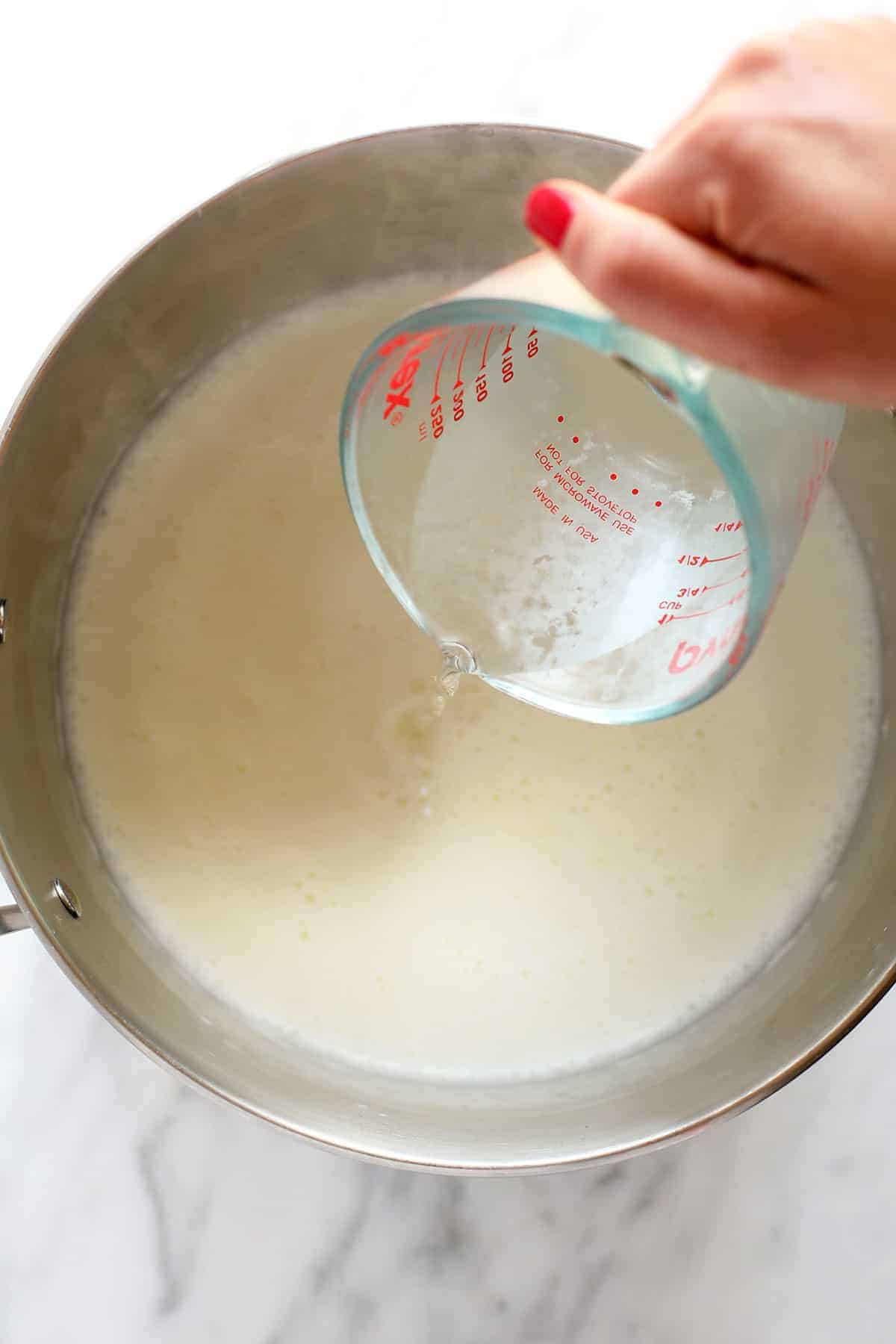 Pouring vinegar into a pot. 