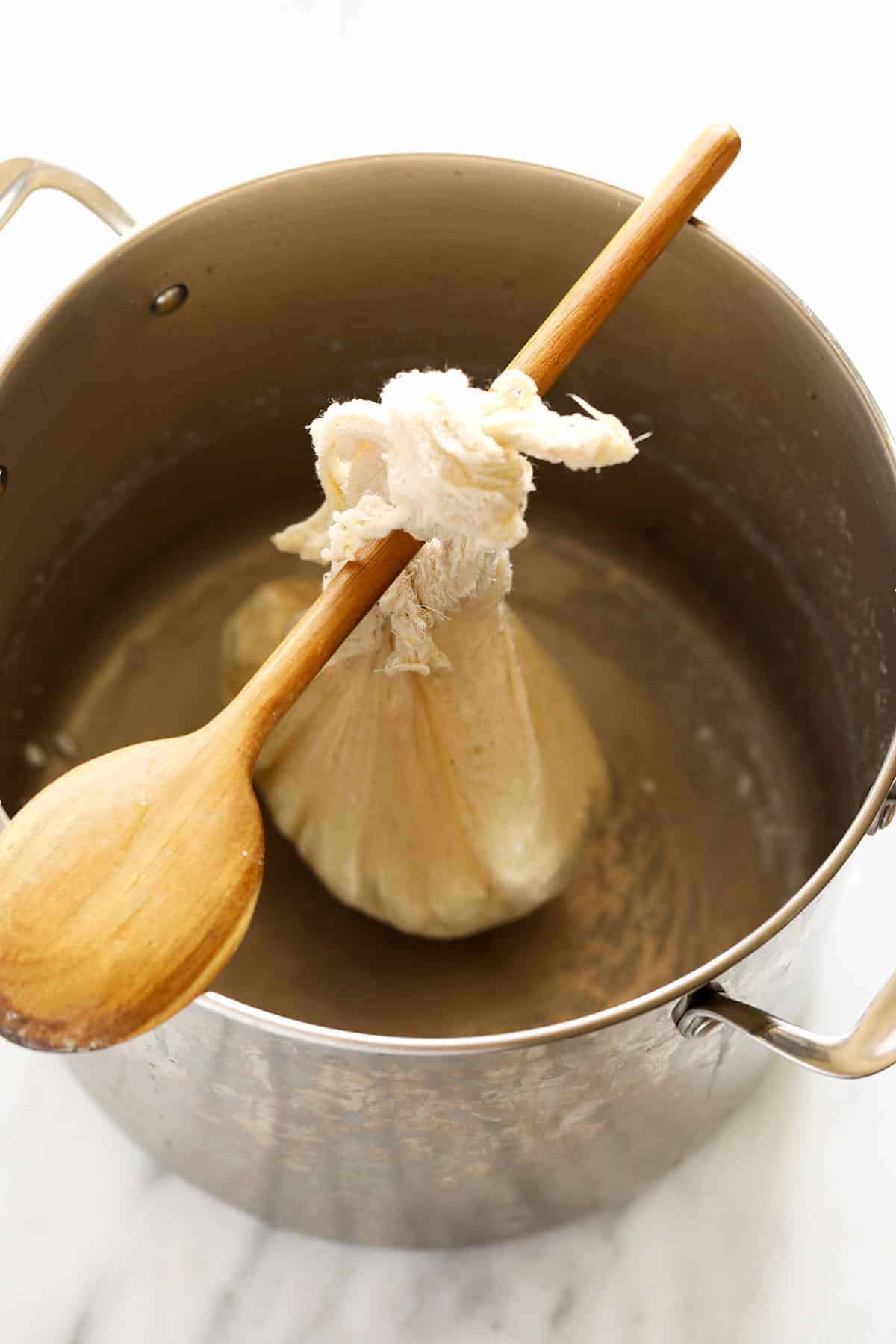 Paneer hanging from a wooden spoon.