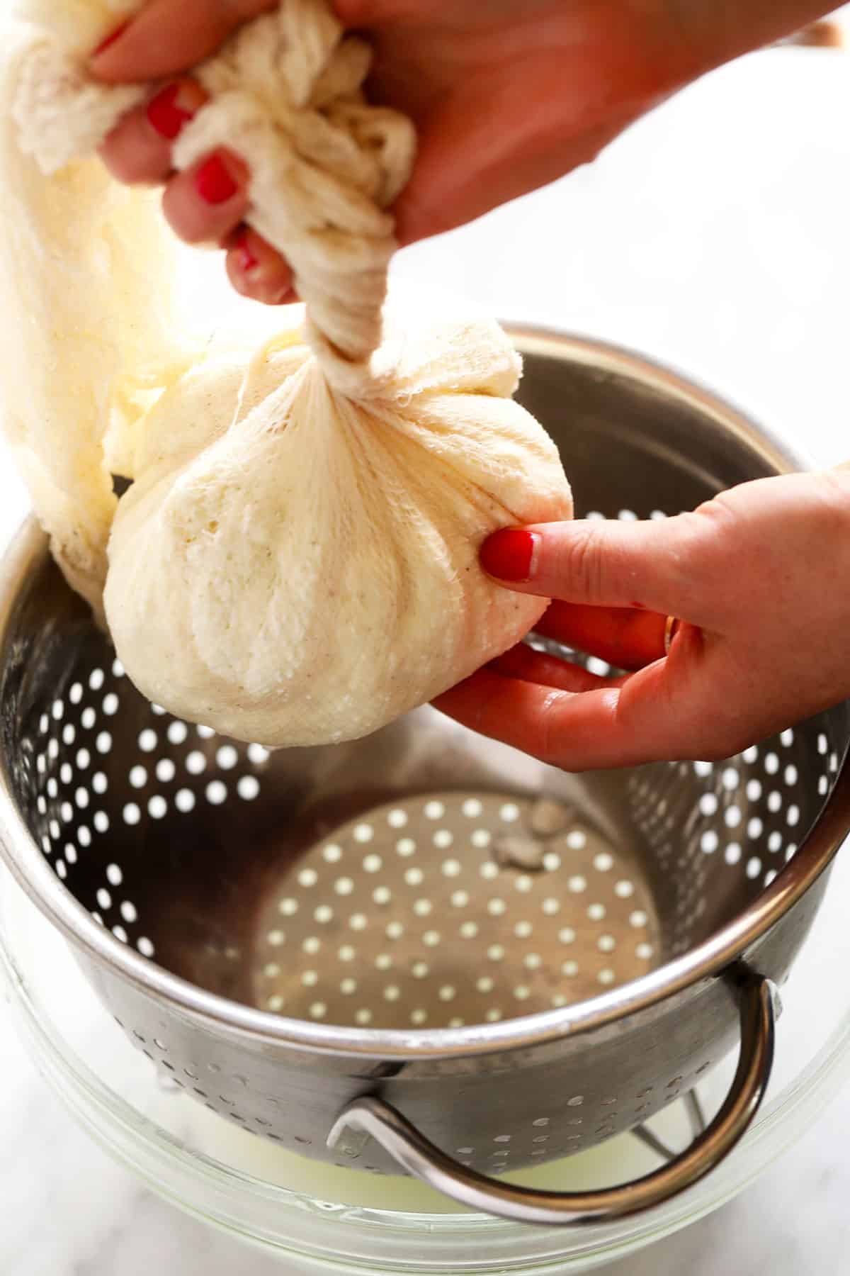 Twisting paneer curd in cheese cloth. 