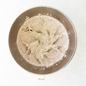 a metal bowl with flour in it on a white surface.