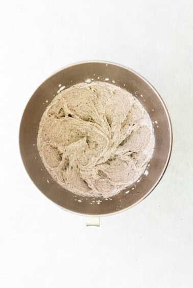 a metal bowl with flour in it on a white surface.