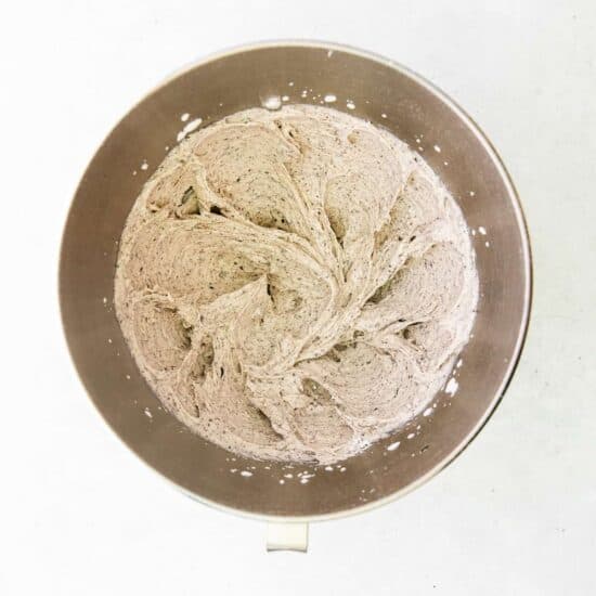 a metal bowl with flour in it on a white surface.
