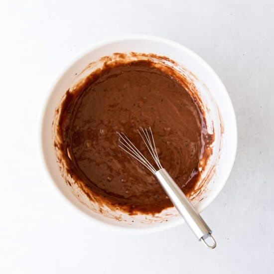 chocolate batter in a white bowl with a whisk.