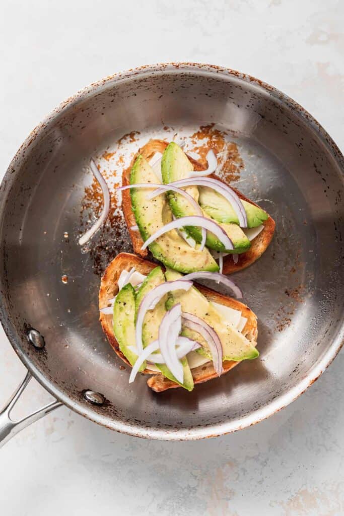 grilled cheese with avocado in pan.