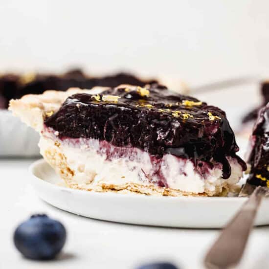 a slice of blueberry cheesecake on a plate with a fork.