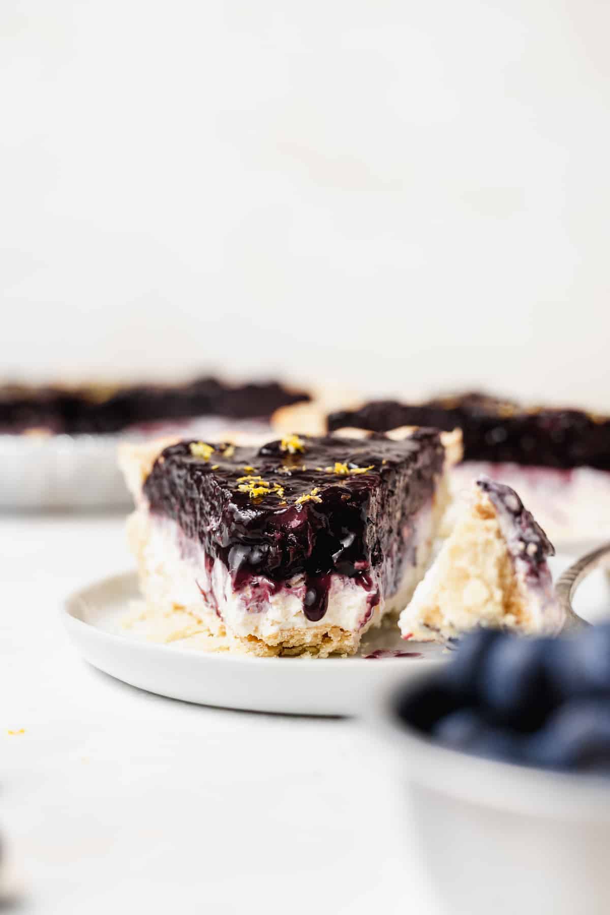 Blueberry cream cheese pie with a bite taken out.