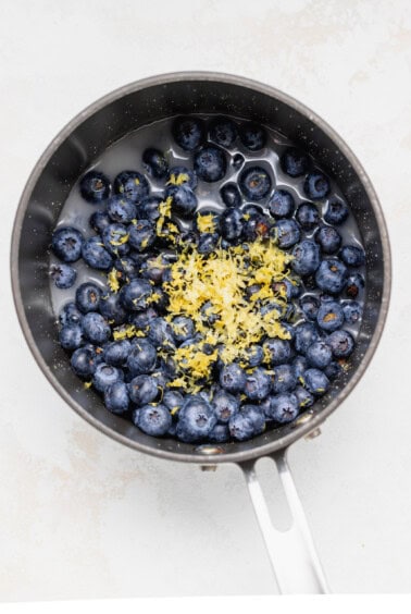 fresh blueberries and lemon zest in a saucepan.