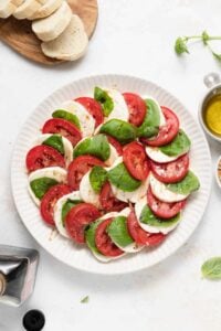 Caprese salad on a plate with fresh basil.